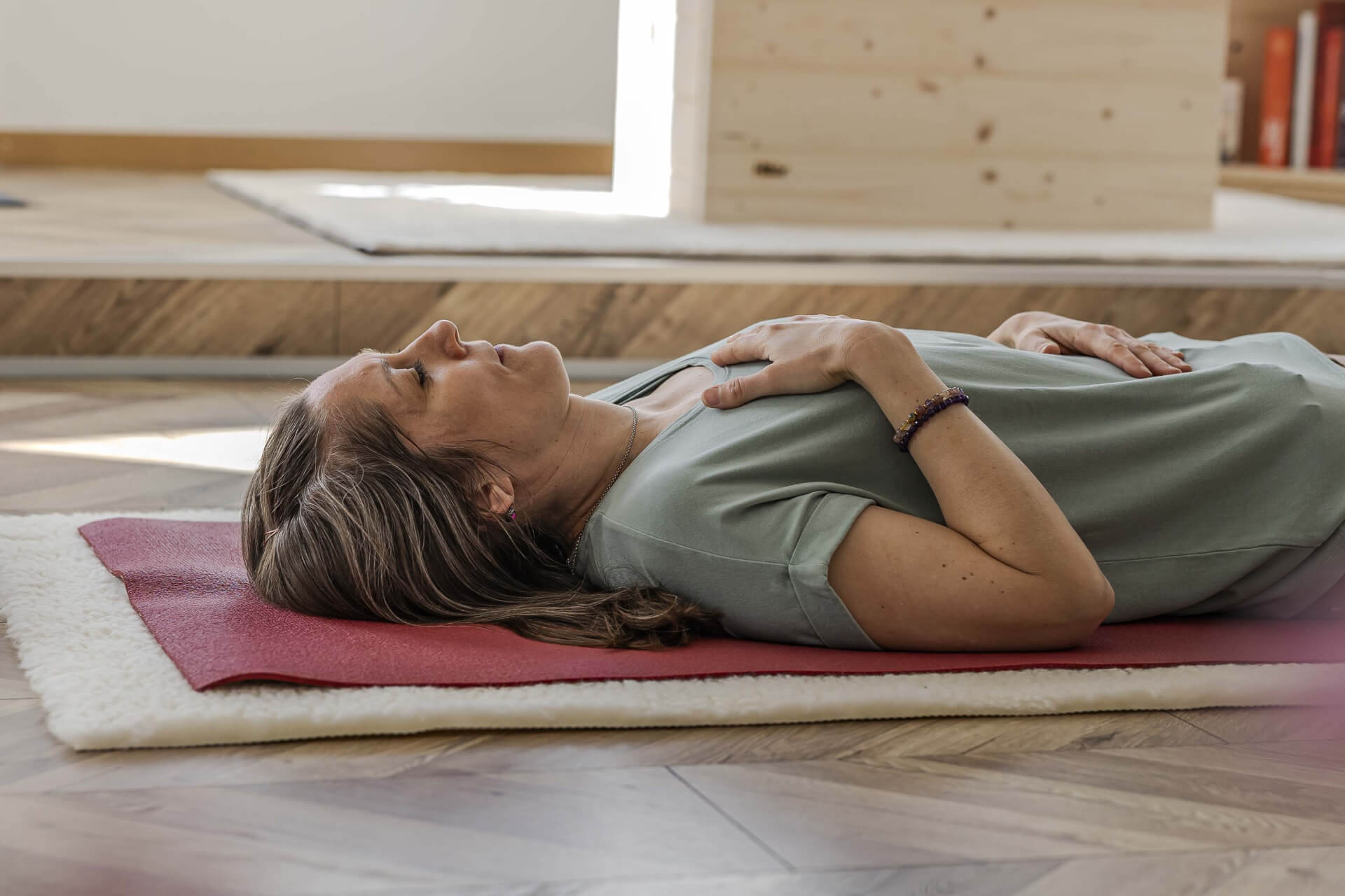 Yogalehrerin Raffaela während Yoga-Einheit auf der Yogamatte