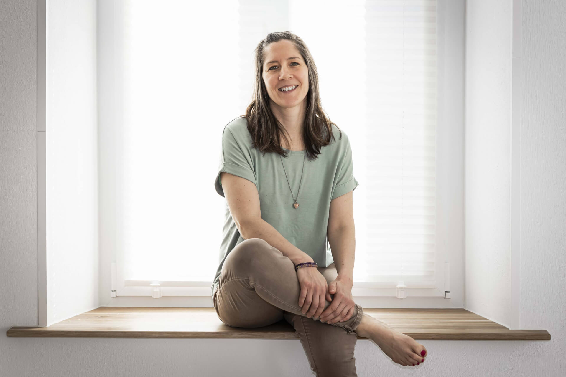 Yogalehrerin sitzend auf Fensterbank im Interview
